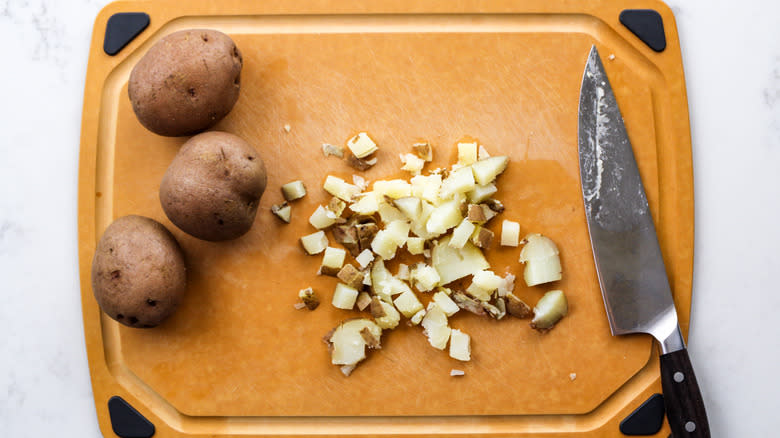 chopped cooked potatoes on cutting board