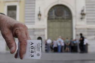 A pensioner holds his priority ticket as he waits to receive part of his pension at a National Bank branch in Athens, Greece, July 6, 2015. REUTERS/Christian Hartmann