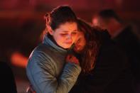 NEWTOWN, CT - DECEMBER 18: Rachel Berger (L), and Greta Waag embrace while visiting a makeshift memorial for shooting victims on December 18, 2012 in Newtown, Connecticut. Funeral services were held in Newtown Tuesday for Jessica Rekos and James Mattioli, both age six, four days after 20 children and six adults were killed at Sandy Hook Elementary School. (Photo by John Moore/Getty Images)