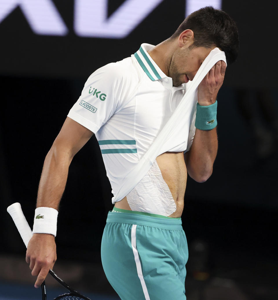 Serbia's Novak Djokovic wipes the sweat from his face during his fourth round match against Canada's Milos Raonic at the Australian Open tennis championship in Melbourne, Australia, Sunday, Feb. 14, 2021.(AP Photo/Hamish Blair)