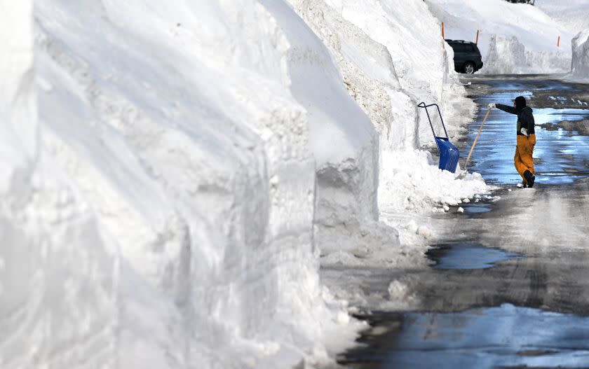 Mammoth Mountain California March 7, 2023-A resident takes a break from shoveling snow on Davison Road Tuesday. Over 550 inches of snow has fallen at the main lodge in Mammoth Mountain as residents try to dig out. (Wally Skalij/(Los Angeles Times)