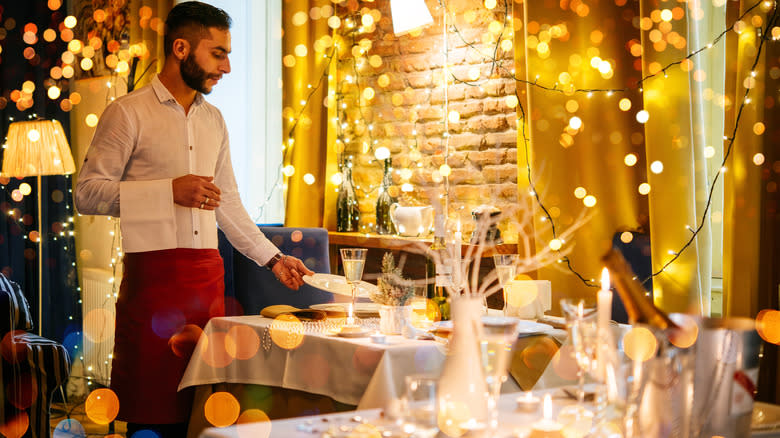 Waiter setting a holiday table 
