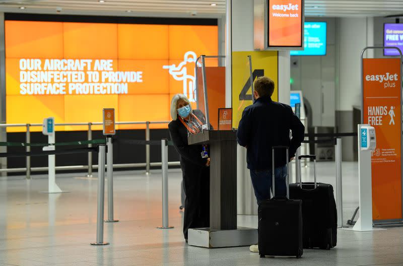 Passenger checks in at an Easy Jet checking area at Gatwick Airport, in Gatwick