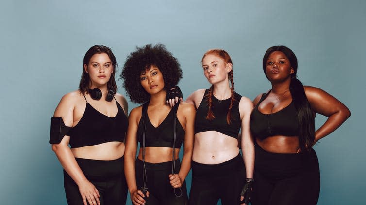 A group of women of different races in black sportswear.