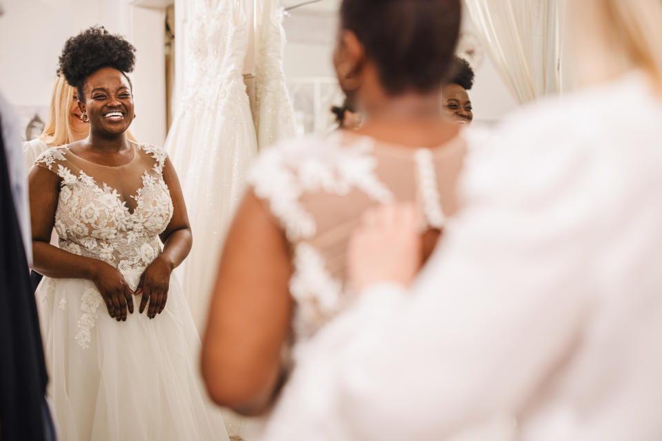 woman trying on a lace bridal dress