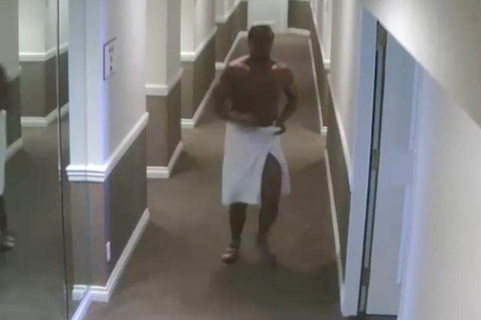 Diddy is seen in a towel chasing Cassie down the corridor towards the elevators, where he attacks her and pushes her to the floor (CNN)