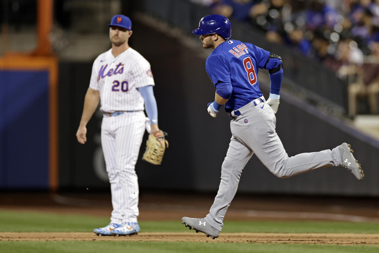 Ian Happ of the Chicago Cubs rounds the bases past Pete Alonso of the New York Mets after Happ hit a home run on Tuesday night. (Photo by Adam Hunger/Getty Images)