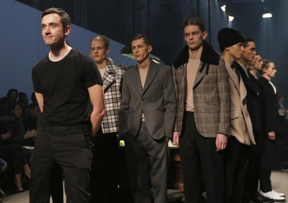 French fashion designer Guillaume Henry, left, poses with models after the presentation of Carven men's fall-winter 2014-2015 fashion collection presented in Paris, Wednesday, Jan.15, 2014. (AP Photo/Jacques Brinon)