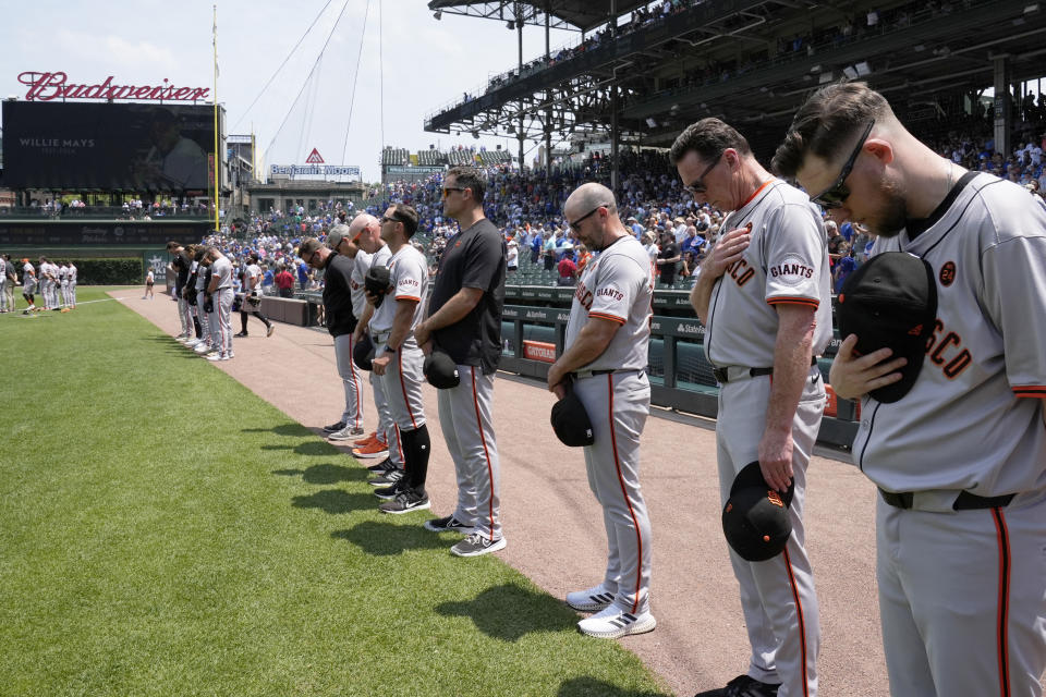 Fans and San Francisco Giants team members stand for a moment of silence for Willie Mays, who died Tuesday, before a baseball game between the Giants and the Chicago Cubs in Chicago, Wednesday, June 19, 2024. (AP Photo/Nam Y. Huh)