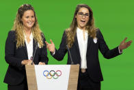 FILE - Italian snowboarder Michela Moioli, left, and Italian skier Sofia Goggia, right, speaking on the podium during the presentation final presentation of the Milan-Cortina candidate cities the first day of the 134th Session of the International Olympic Committee (IOC), at the SwissTech Convention Centre, in Lausanne, Switzerland, Monday, June 24, 2019. Defending Olympic gold medalists Sofia Goggia and Michela Moioli both come from the Bergamo area that was the first epicenter of COVID-19 in Europe. Goggia skis with a design of Bergamo's skyline on the back of her racing helmet. Moioli lost her grandmother to the virus. (Laurent Gillieron/Keystone via AP, File)