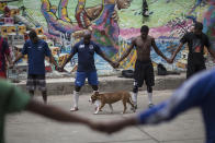 Friends and neighbors of the late Douglas Rafael da Silva Pereira pray before playing soccer in a plaza near the spot where Silva Pereira's body was found in the Pavao Pavaozinho slum of Rio de Janeiro, Brazil, Wednesday, April 23, 2014. On Tuesday night, angry residents who blame police for his death set fires and showered homemade explosives and glass bottles onto a busy avenue in the city's main tourist zone following the killing of the popular local figure. (AP Photo/Felipe Dana)