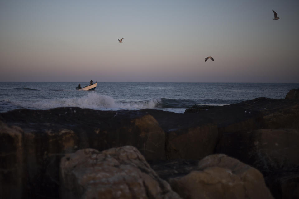 Fishermen on their boat return from a fishing trip on the Mediterranean Sea, in the Israeli Arab village of Jisr al-Zarqa, Israel, in the early morning of Thursday, Feb. 25, 2021. After weathering a year of the coronavirus pandemic, an oil spill in the Mediterranean whose culprits remain at large delivered another blow for the fishermen of Jisr al-Zarqa. (AP Photo/Ariel Schalit)