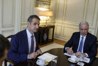 Greece's Prime Minister Kyriakos Mitsotakis, left, looks on next to European Commissioner for Migration and Home Affairs Dimitris Avramopoulos during a meeting about migration policy in Athens, on Monday , July 15, 2019. (AP Photo/Petros Giannakouris)