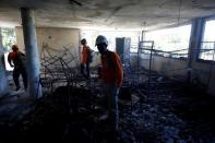 Civil protection workers stand inside a bedroom at an orphanage after it was destroyed in a fire, in Port-au-Prince