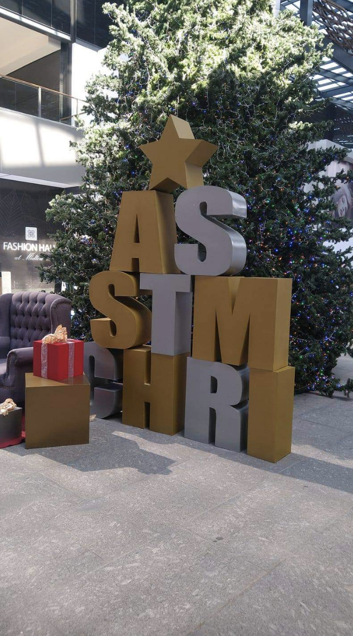 Large letters in front of a large tree in a mall: &quot;AS / STM / CHRI&quot;