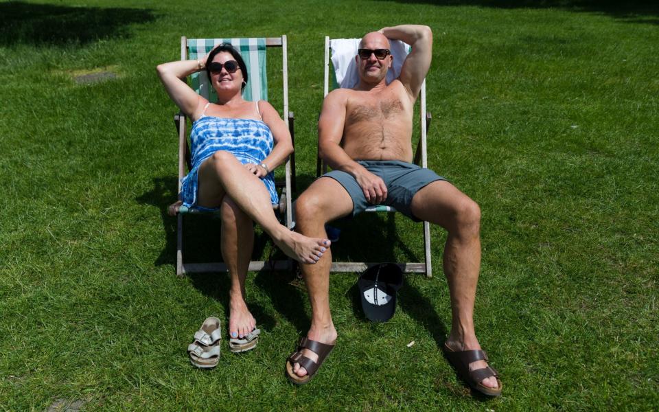 A couple sunbathing in deck chairs during the hot weather in Hyde Park  - VICKIE FLORES/EPA-EFE/Shutterstock