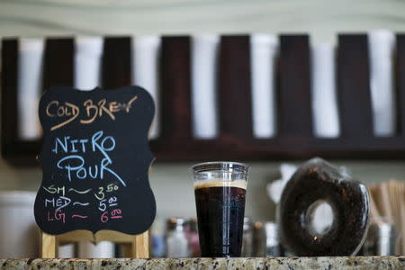 A coffee cup of a nitrogen-infused cold brew coffee from Brooklyn-based roaster Gillies Coffee out of a tap is seen at Guy & Gallard cafeteria in New York July 31, 2015. REUTERS/Eduardo Munoz