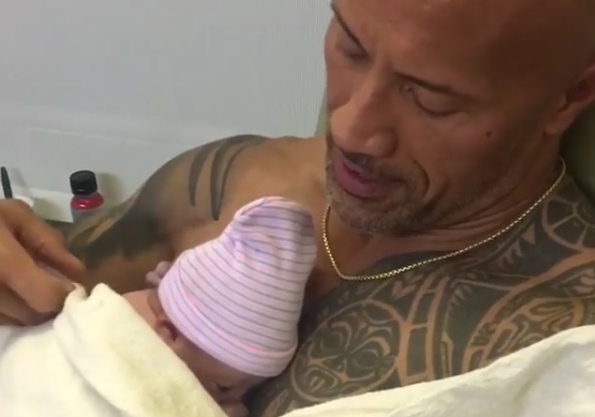 Dwayne Johnson holds his newborn baby girl. (Photo: Lauren Hashian via Instagram)