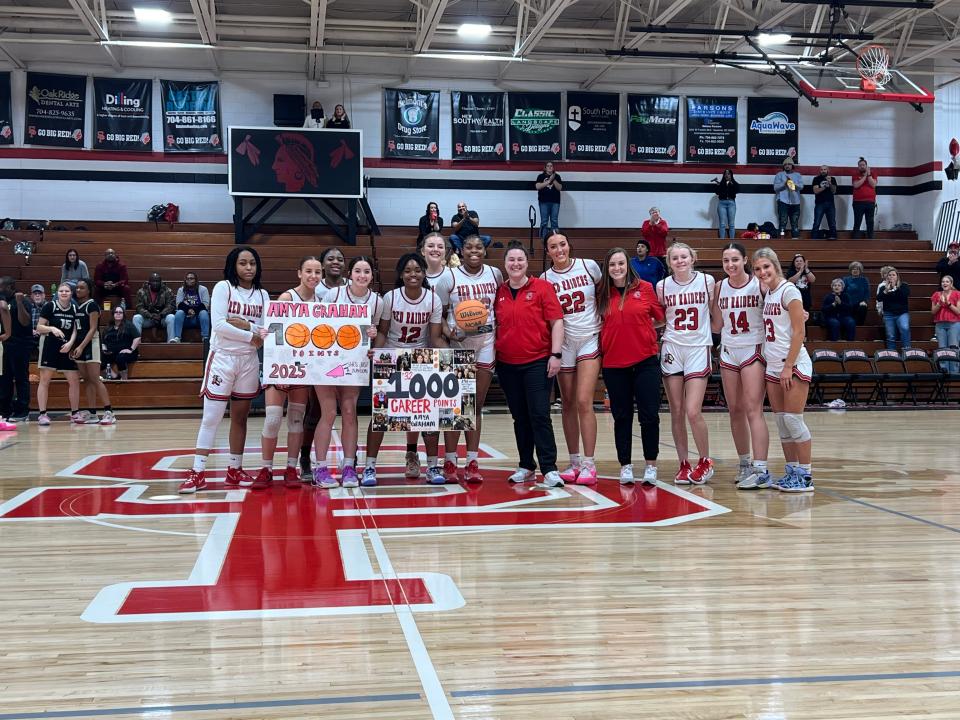 South Point girls basketball standout Amya Graham celebrates with teammates and coaches after earning her 1,000th career point Friday, Feb. 16, 2024.
