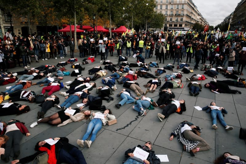 People stage a "die-in" at Place de la Republique during a demonstration against femicide and violence against women in Paris