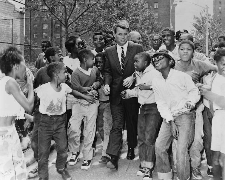 Politician surrounded by children in a street