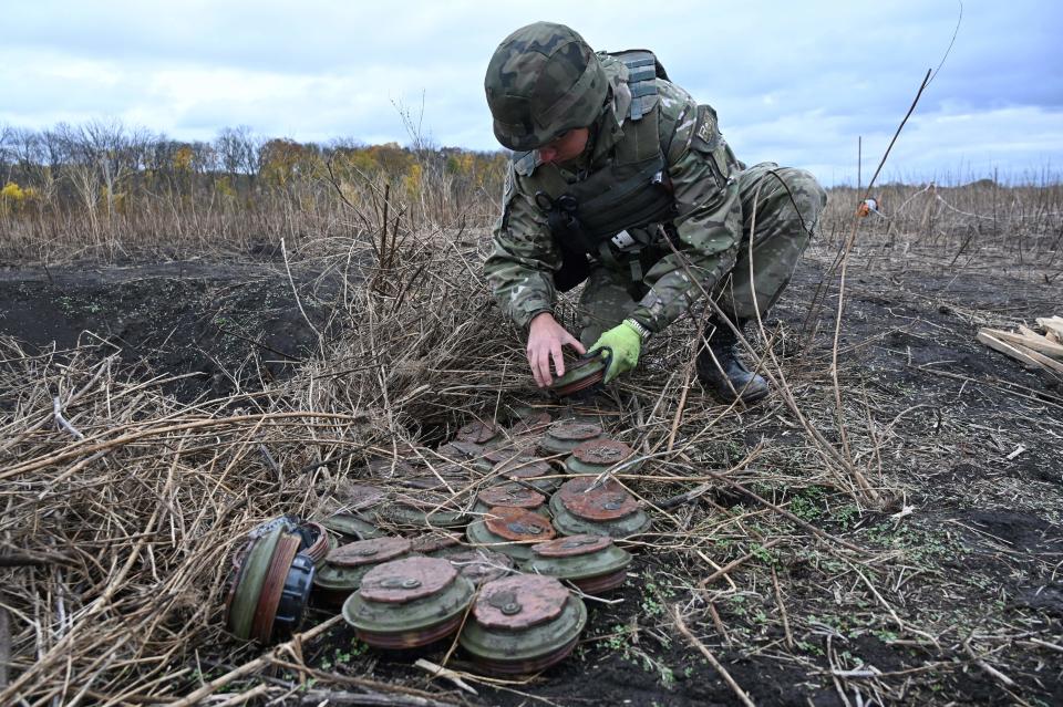 A deminer of Ukrainian national police inspects mines that were found in a field in Izyum district, Kharkiv region amid the Russian invasion of Ukraine (AFP via Getty Images)