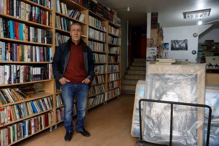 Armen Demirjiyan, a bookseller and member of a small Armenian community in largely Kurdish Diyarbakir, 55, poses in front of old books in Diyarbakir, Turkey, April 6, 2017. REUTERS/Umit Bektas