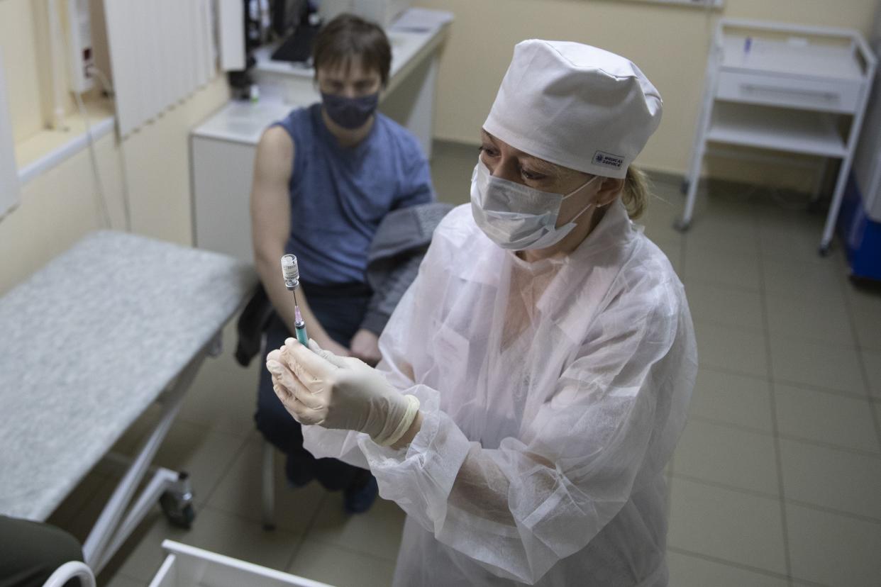 A medical worker, right, prepares a shot of Russia's Sputnik V coronavirus vaccine in Moscow, Russia on Wednesday, Dec. 30, 2020. Russia's Health Ministry has allowed a domestically-designed coronavirus vaccine to be given to people older than 60. Sputnik V's developers have said data suggests the vaccine was 91% effective, a conclusion based on 78 coronavirus infections among nearly 23,000 participants. That's far fewer cases than Western drugmakers have accumulated during final testing before analyzing how well their vaccine candidates worked.