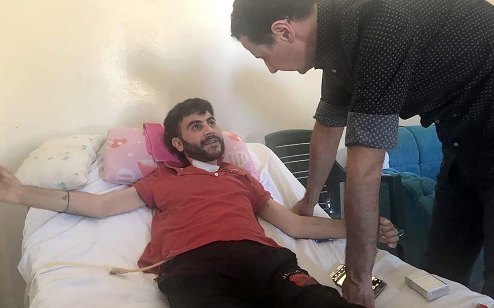 Bashar al-Assad visits an injured soldier in Hama province in a photographed released by the Syrian presidency on June 27 - Credit: Sana via Reuters