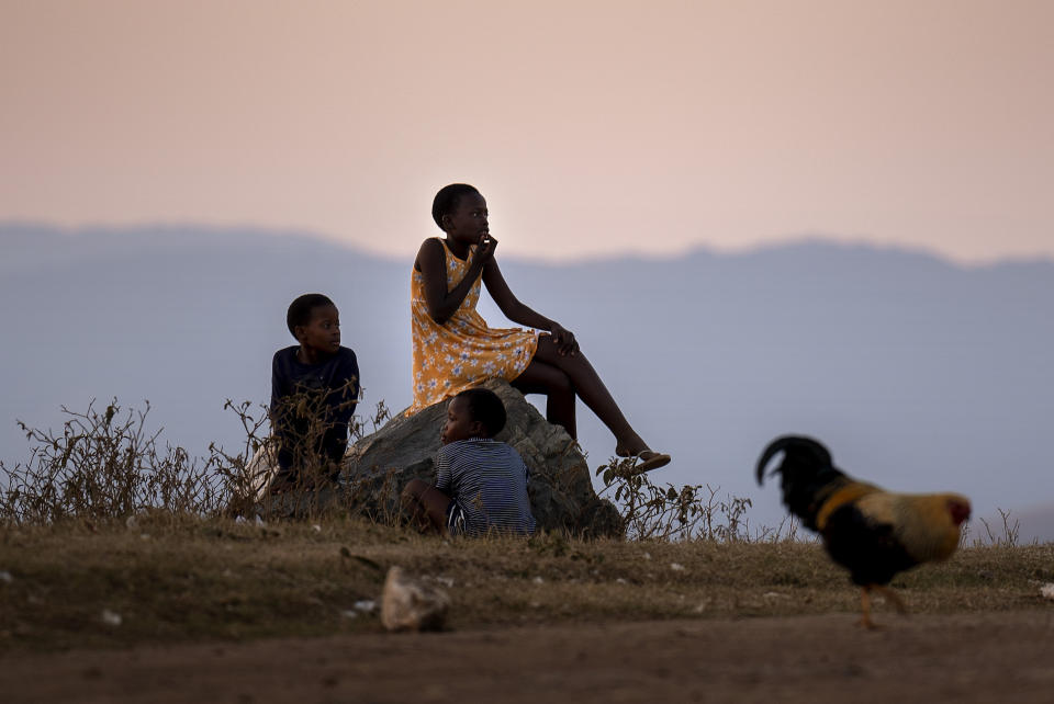 Children sit by the side of the road next to a polling station, during general elections in Nkandla, Kwazulu Natal, South Africa, Wednesday May 29, 2024. South Africans are voting in an election seen as their country's most important in 30 years, and one that could put them in unknown territory in the short history of their democracy, the three-decade dominance of the African National Congress party being the target of a new generation of discontent in a country of 62 million people — half of whom are estimated to be living in poverty. (AP Photo/Emilio Morenatti)