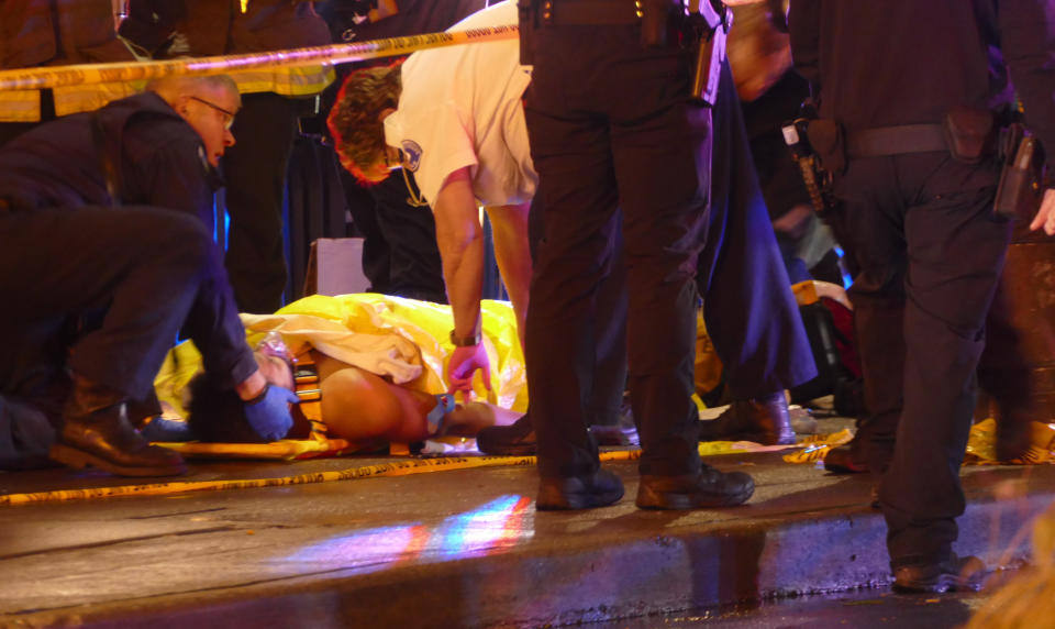 Officers attend to one of several shooting victims, Wednesday, Jan. 22, 2020, in Seattle, after a gunman opened fire in the heavily trafficked downtown area. (David Silver via AP)