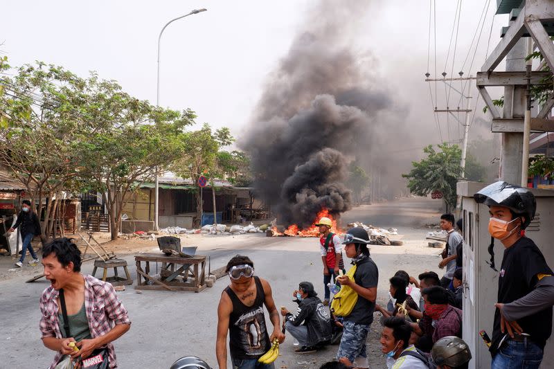 Demonstrators gather behind barricades during a protest against the military coup in Mandalay