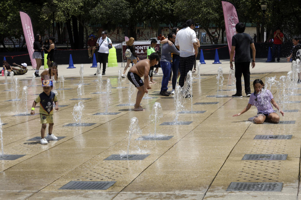 Familias y niños se refrescan en las fuentes de agua del Monumento a la Revolución, en Ciudad de México (Luis Barron/Getty Images)