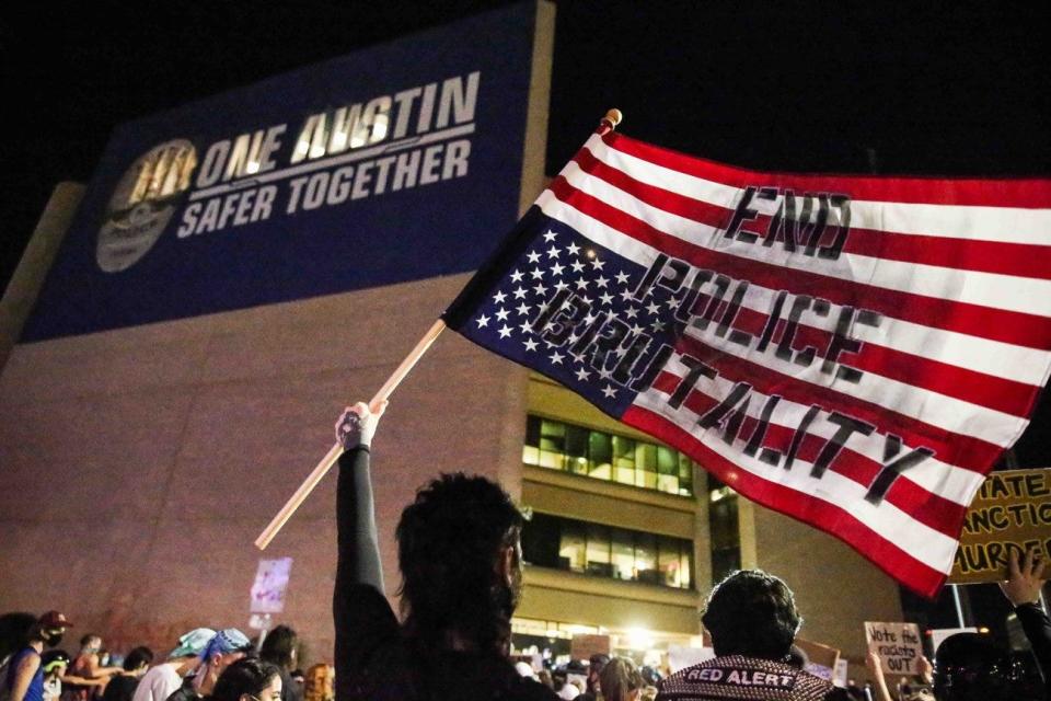 Protesters display signs at Austin police headquarters during a Black Lives Matter rally in Austin on June 4, 2020.