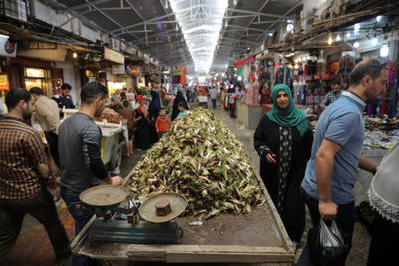 People walk through a market in eastern Mosul, Iraq, April 19, 2017. REUTERS/Marko Djurica