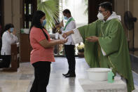 Catholic priest Fr. Ian Espartero distributes communion during Mass to only a few parishioners as a measure to prevent the spread of COVID19 at the Our Lady of Consolation Parish on Sunday, Aug. 2, 2020, in Quezon city, Philippines. Coronavirus infections in the Philippines continues to surge Sunday as medical groups declared the country was waging a losing battle against the contagion and asked the president to reimpose a lockdown in the capital. (AP Photo/Aaron Favila)