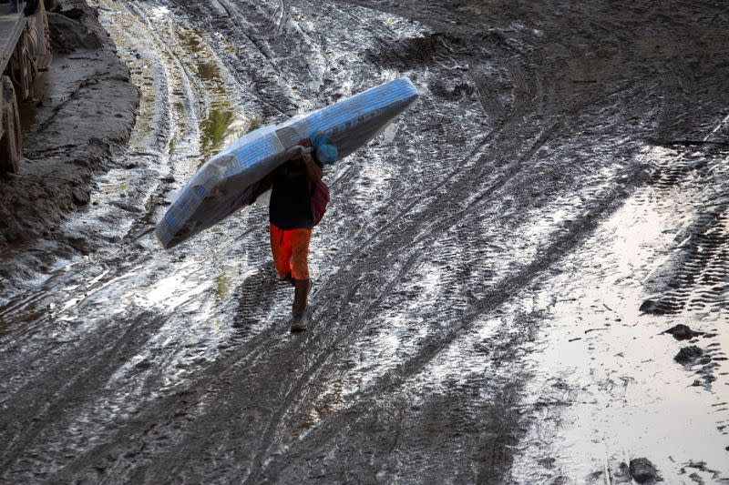 Un hombre carga un colchón después del huracán Otis cerca de Acapulco, México