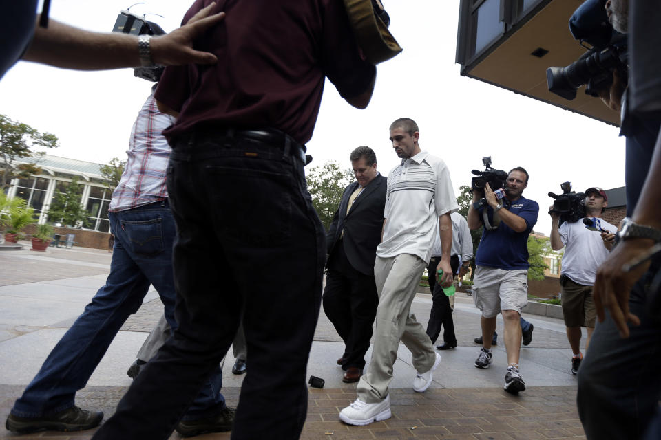 Kenneth W. Smith Jr., center, accompanied by his lawyer Bill Brennan, center left, walks near the U.S. Courthouse, Friday, Sept. 7, 2012, in Philadelphia. Smith was arrested and is charged with making a hoax threat that led authorities to recall a plane in midair to the Philadelphia airport. Federal authorities charged 26-year-old Smith Jr. with conveying false and misleading information. According to a criminal complaint, Smith called police at the airport on Thursday, Sept. 6, 2012 and falsely reported a passenger was carrying an explosive substance. Authorities then recalled a Dallas-bound US Airways flight to Philadelphia. (AP Photo/Matt Rourke)