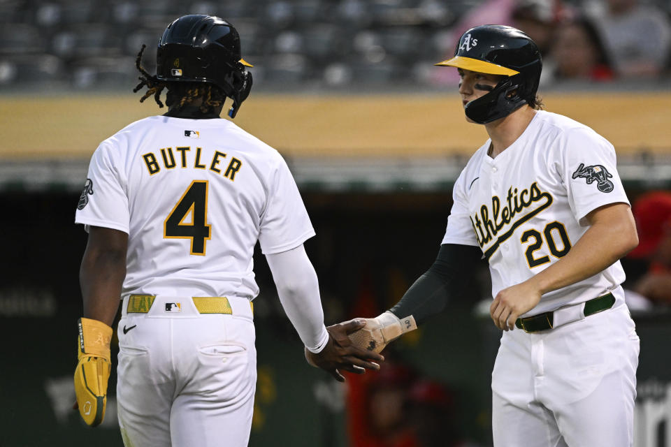 'Oakland Athletics second base Zack Gelof (20) high fives outfielder Lawrence Butler (4) as he crosses home plate against the Los Angeles Angels during the sixth inning of a baseball game Tuesday, July 2, 2024, in Oakland, Calif. (AP Photo/Eakin Howard)