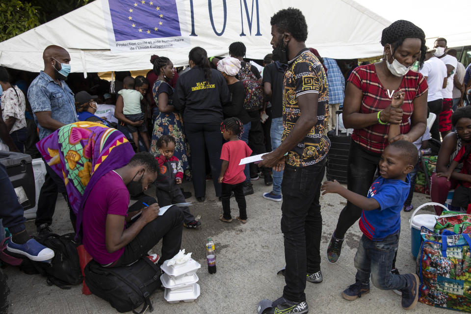 Haitian migrants deported from the US register after arriving to the Toussaint Louverture International Airport in Port-au-Prince, Haiti, Sunday, Sept. 19, 2021. Thousands of Haitian migrants have been arriving to Del Rio, Texas, to ask for asylum in the U.S., as authorities begin to deported them to back to Haiti. (AP Photo/Rodrigo Abd)