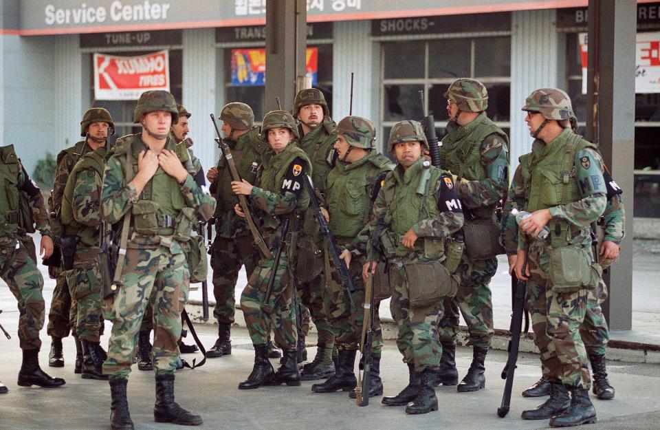 National Guardsmen stand ready for deployment near the corner of Wilshire and Vermont in Los Angeles on Thursday, May 1, 1992, as a citywide curfew goes into effect a day after the verdicts were handed down in the Rodney King beating trial.