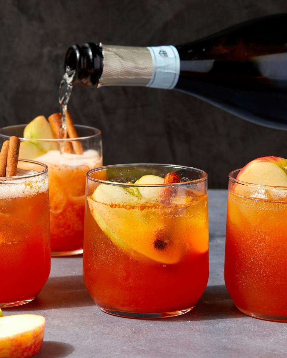 apple cider spritzes garnished with apples and cinnamon sticks