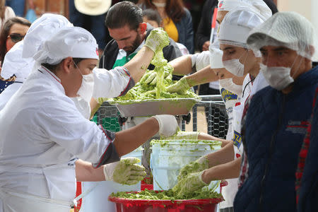 Volunteers from a culinary school mash avocados as they attempt to set a new Guinness World Record for the largest serving of guacamole in Concepcion de Buenos Aires, Jalisco, Mexico September 3, 2017. REUTERS/Fernando Carranza