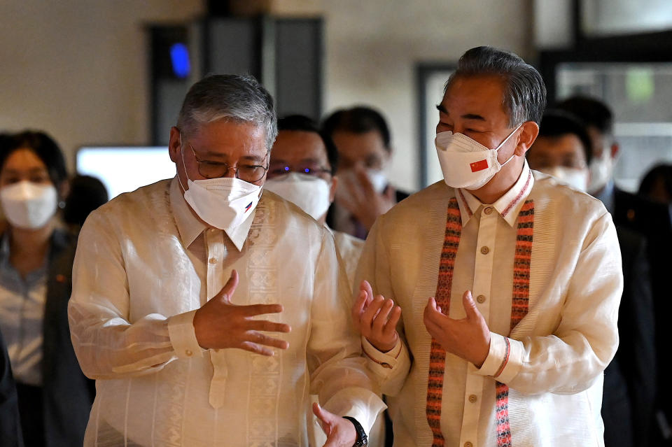 Philippine Foreign Affairs Secretary Enrique Manalo, left, chats with Chinese Foreign Minister Wang Yi as they arrive for bilateral talks at the Department of Foreign Affairs in Manila, Philippines on Wednesday, July 6, 2022. (Jam Sta Rosa/Pool Photo via AP)