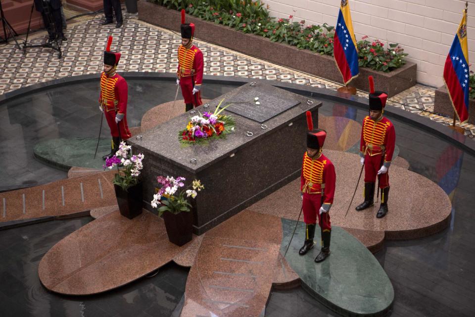 Presidential guards stand next to the tomb of Venezuela's late President Hugo Chavez at the former military barracks that was turned into Chavez's mausoleum in Caracas, Venezuela, Wednesday, March 5, 2014. Venezuelans are commemorating the one year anniversary of Chavez's death. (AP Photo/Rodrigo Abd)