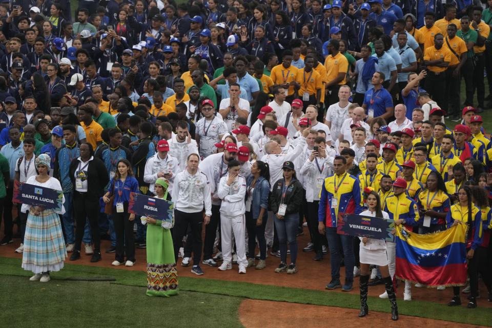 Athletes from Santa Lucia, from left, Russia, and Venezuela, take part in the Alba Games' opening ceremony at the baseball stadium in La Guaira, Venezuela, Friday, April 21, 2023. (AP Photo/Ariana Cubillos)