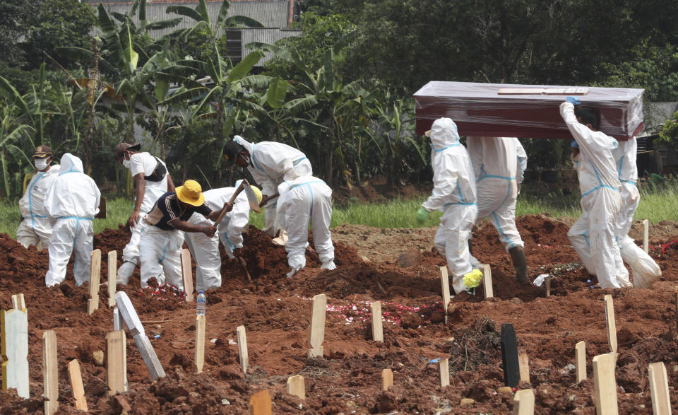 Workers carry a coffin for burial at the special section of the Pedurenan cemetery which was opened to accommodate the surge in deaths during the coronavirus outbreak in Bekasi, West Java, Indonesia on the outskirts of Jakarta, Indonesia, Sunday, July 11, 2021. (AP Photo/Achmad Ibrahim)