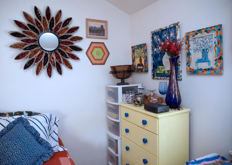 Kristine Kadlec's bedroom features a yellow drawer set that she found and repainted, along with other repurposed items  Above the dresser is a collage she made.