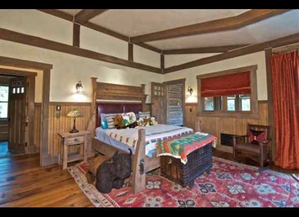 Natural wood beams and details are mixed with colorful patterns and fabrics in a bedroom.