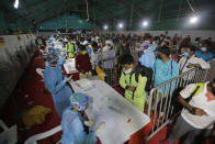 Indian passengers queue up to test for COVID-19 at a facility erected at a railway station to screen people coming from outside the city, in Ahmedabad, India, Friday, Sept. 18, 2020. India's coronavirus cases jumped by another 96,424 in the past 24 hours, showing little sign of leveling. India is expected to have the highest number of confirmed cases within weeks, surpassing the United States, where more than 6.67 million people have been infected. (AP Photo/Ajit Solanki)